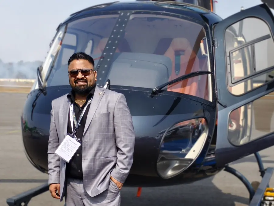 Karan Suri beside a helicopter at an Indian air show
